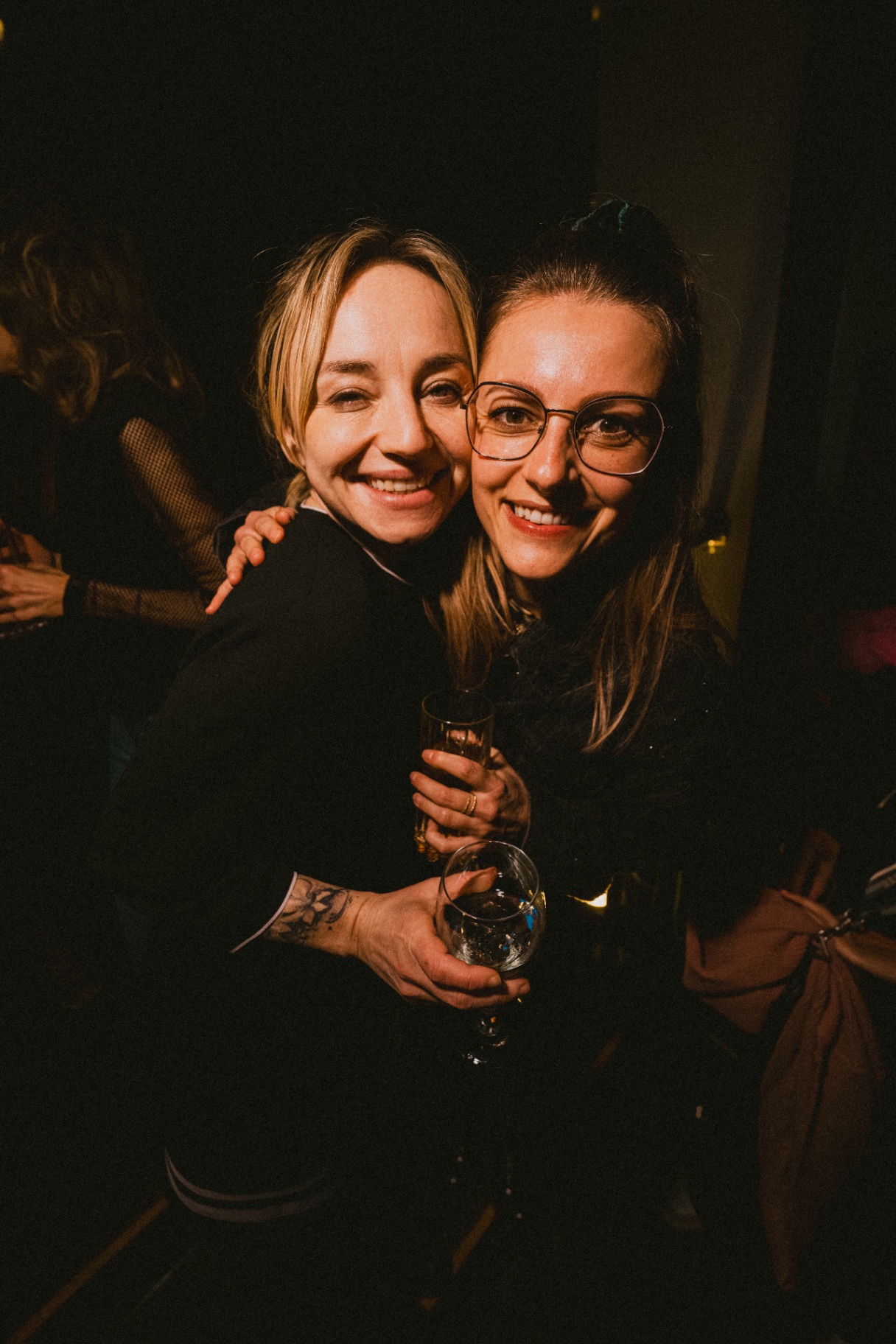 Two friends smiling with drinks at Jimmy's